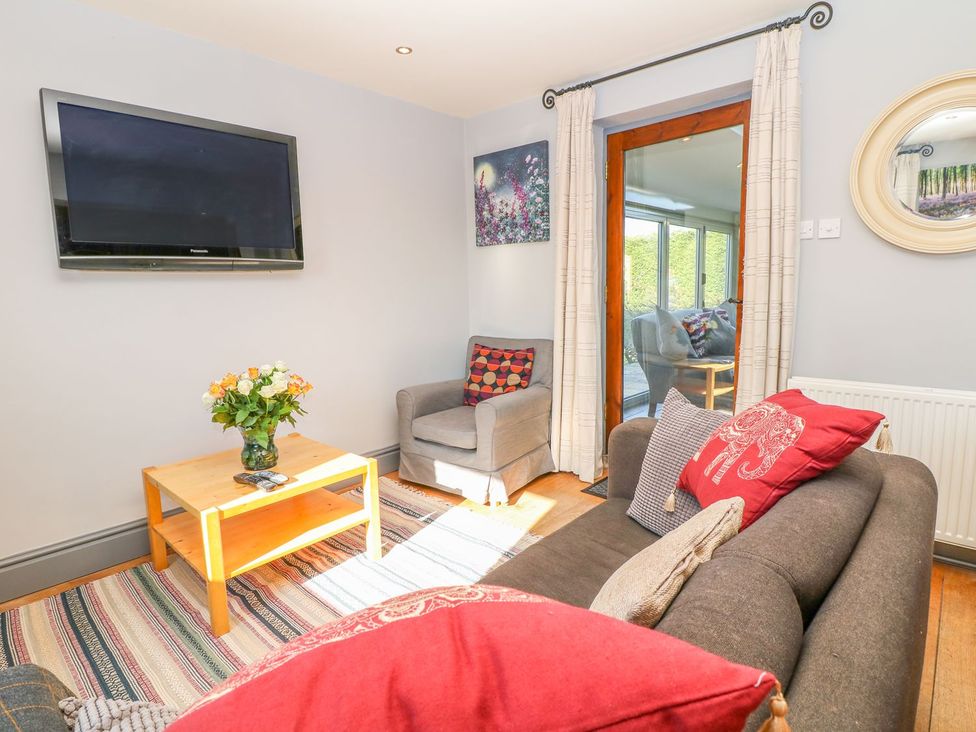 A living room with a television and sofa at Peters Lea in Bakewell