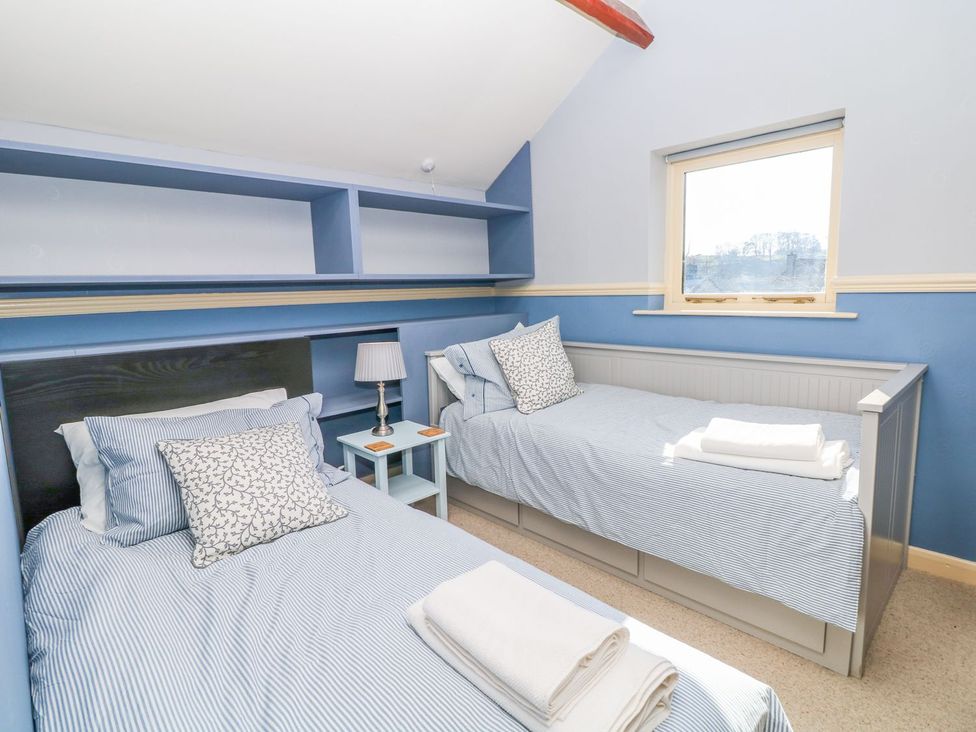 A bedroom with two single beds and a window at Peters Lea in Bakewell