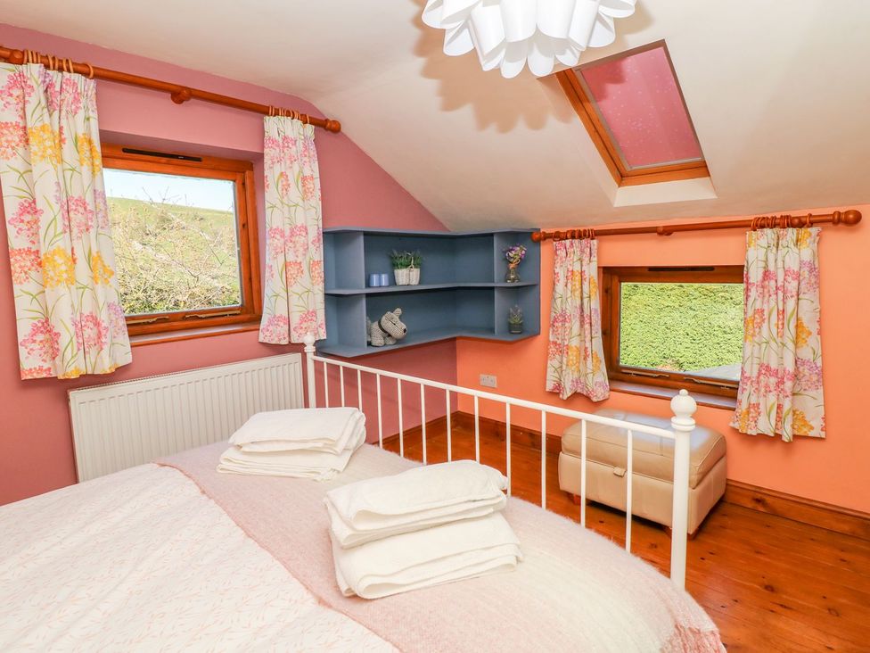 A bedroom with a bed and shelves at Peters Lea in Bakewell