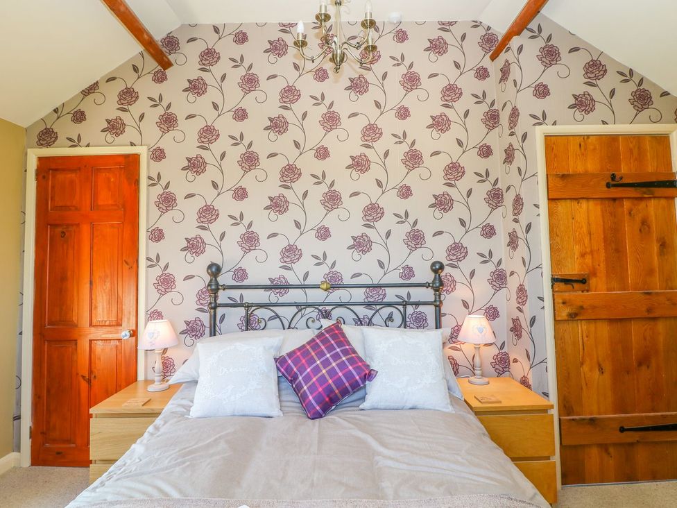 A bedroom with a bed and two doors at Peters Lea in Bakewell