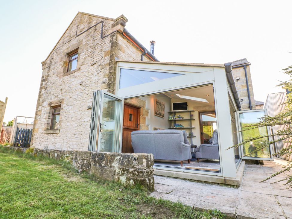 A living room with glass doors and a sofa at Peters Lea in Bakewell