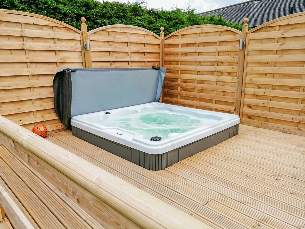 An outdoor area with a hot tub and wooden decking at Peters Lea Bakewell