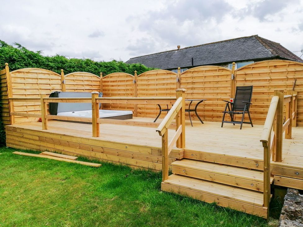An outdoor space with a deck and hot tub at Peters Lea in Bakewell