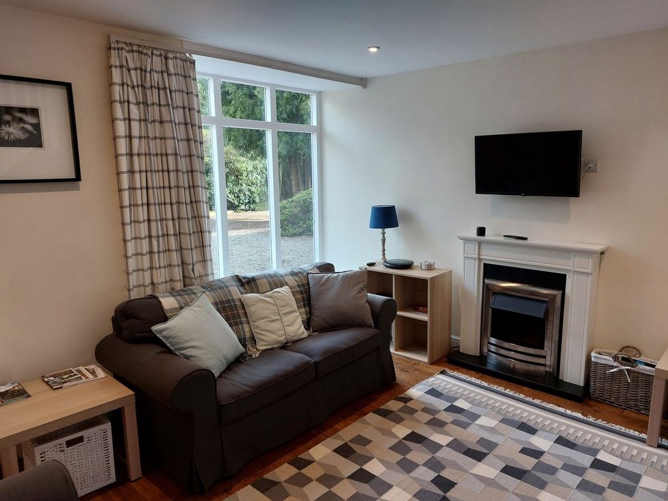 A living room with a sofa and television at The Coach House- Canonbie