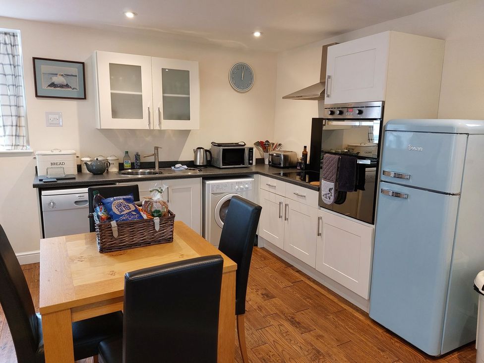A kitchen with a table and chairs at The Coach House- Canonbie in Canonbie near Langholm