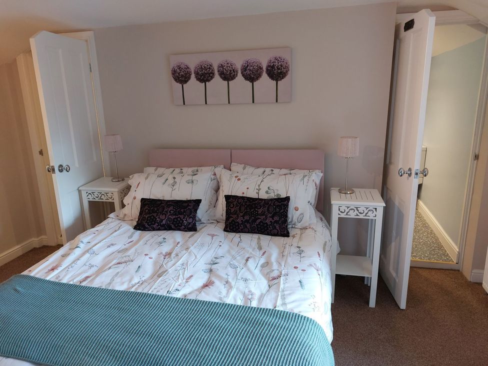 A bedroom with a bed and bedside table at The Coach House- Canonbie near Langholm