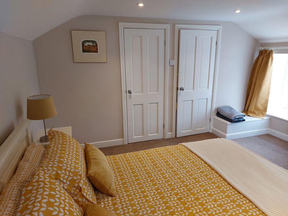 A bedroom with a bed and two doors at The Coach House- Canonbie near Langholm