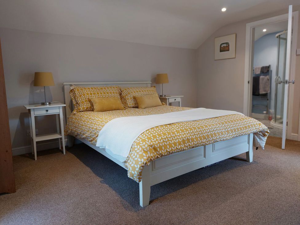 A bedroom with a bed and nightstands at The Coach House- Canonbie near Langholm