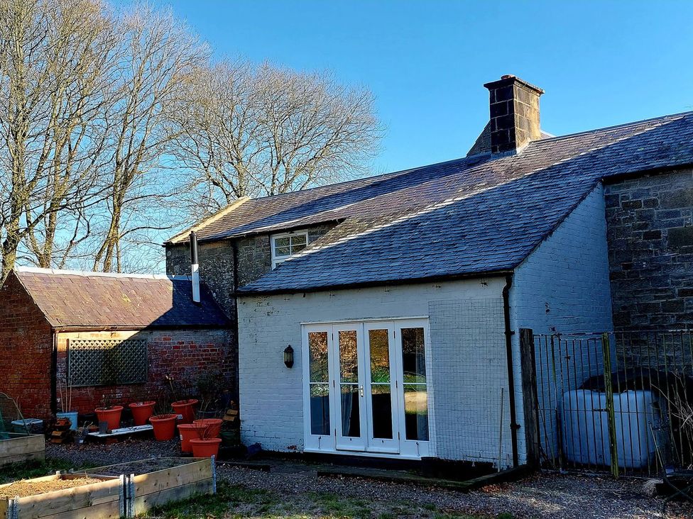 A house with a garden and trees at The Coach House- Canonbie near Langholm