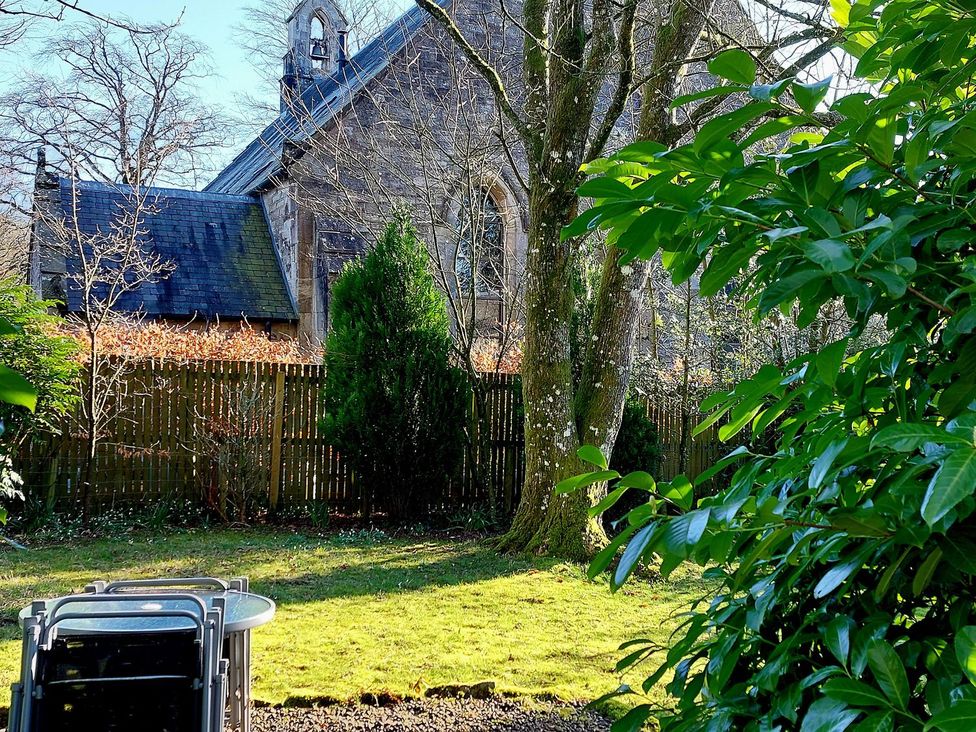 A garden with a table and chairs at The Coach House- Canonbie near Langholm