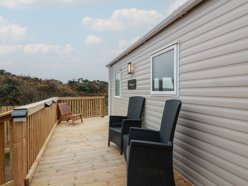 An outdoor deck with chairs and a sign at Ellies House in Stranraer