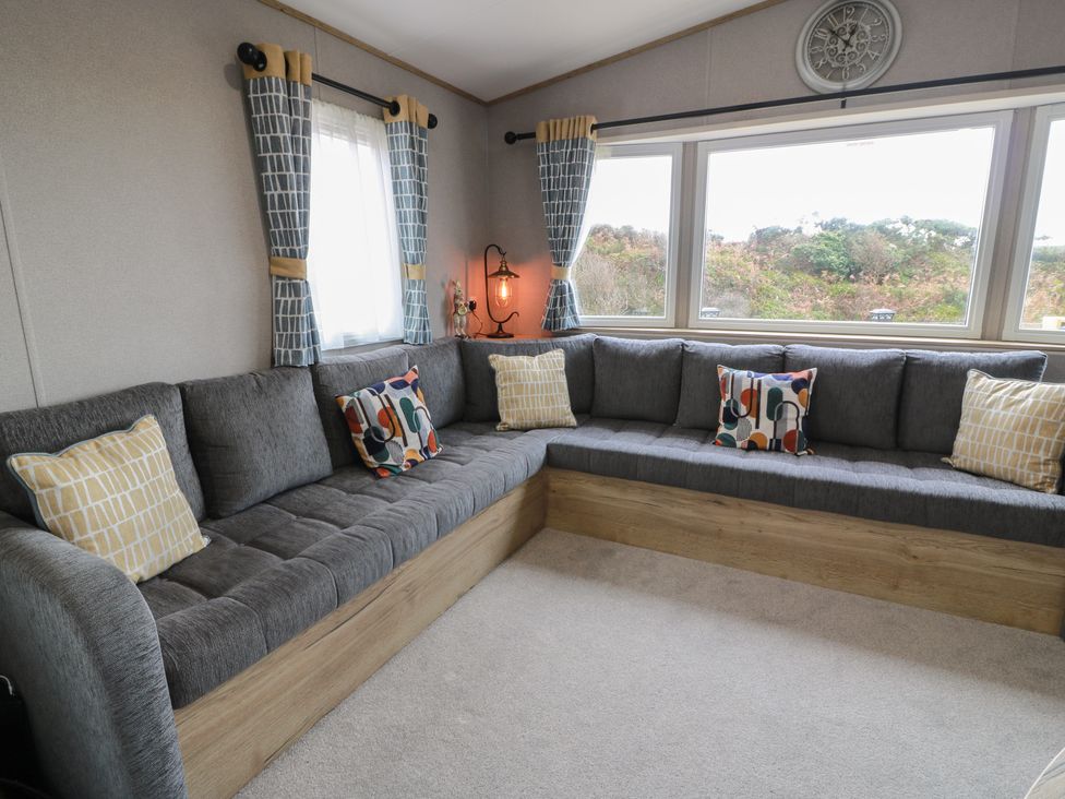 A living room with a sectional sofa and large window at Ellies House in Stranraer