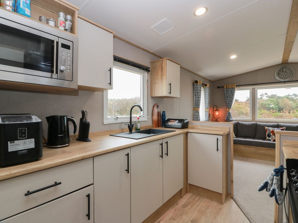 A kitchen with appliances and a sofa at Ellies House in Stranraer