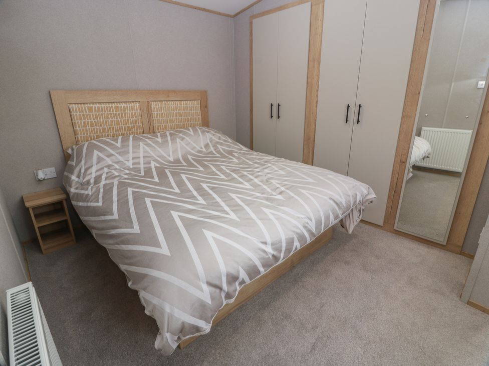 A bedroom with a bed and wardrobe at Ellies House in Stranraer