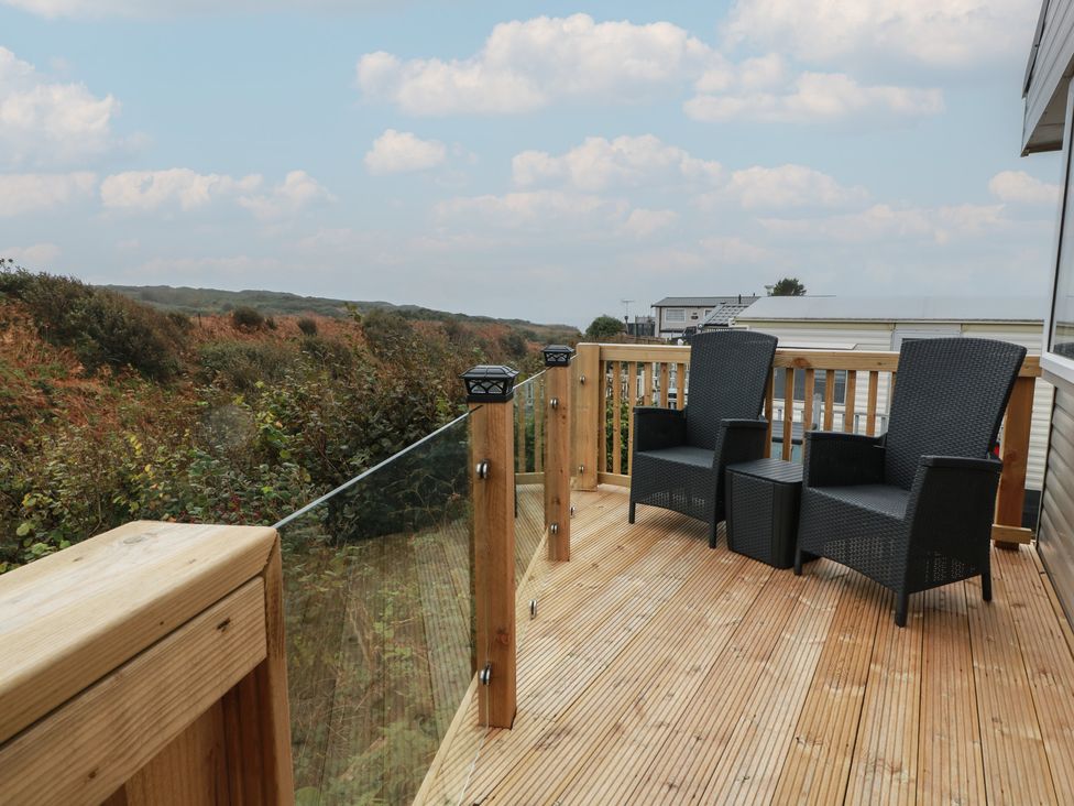 A deck with chairs overlooking a landscape at Ellies House in Stranraer