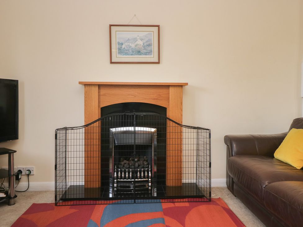 A living room with a fireplace and a television at Castle Terrace in Penrith