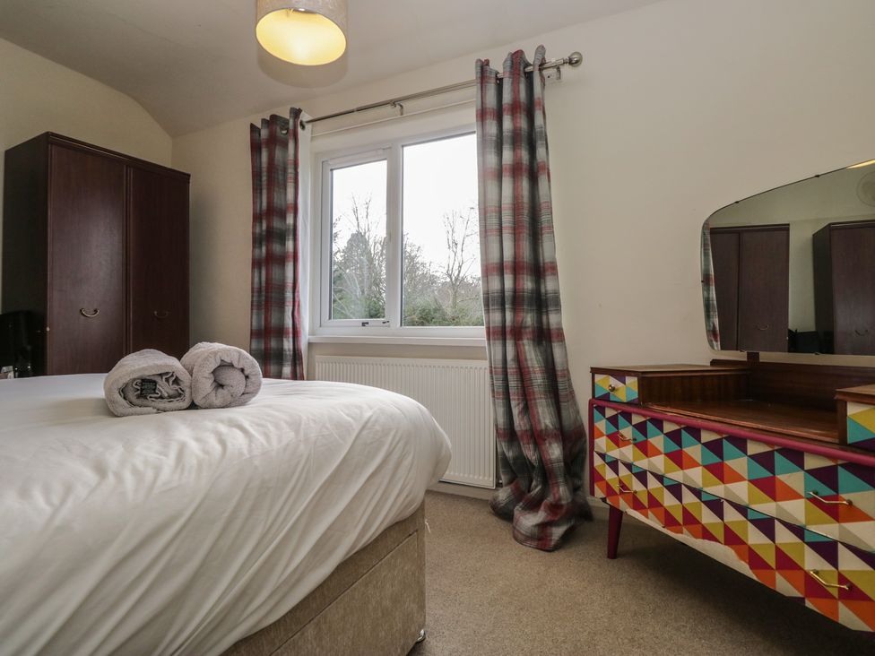 A bedroom with a bed and colorful dressing table at Castle Terrace in Penrith