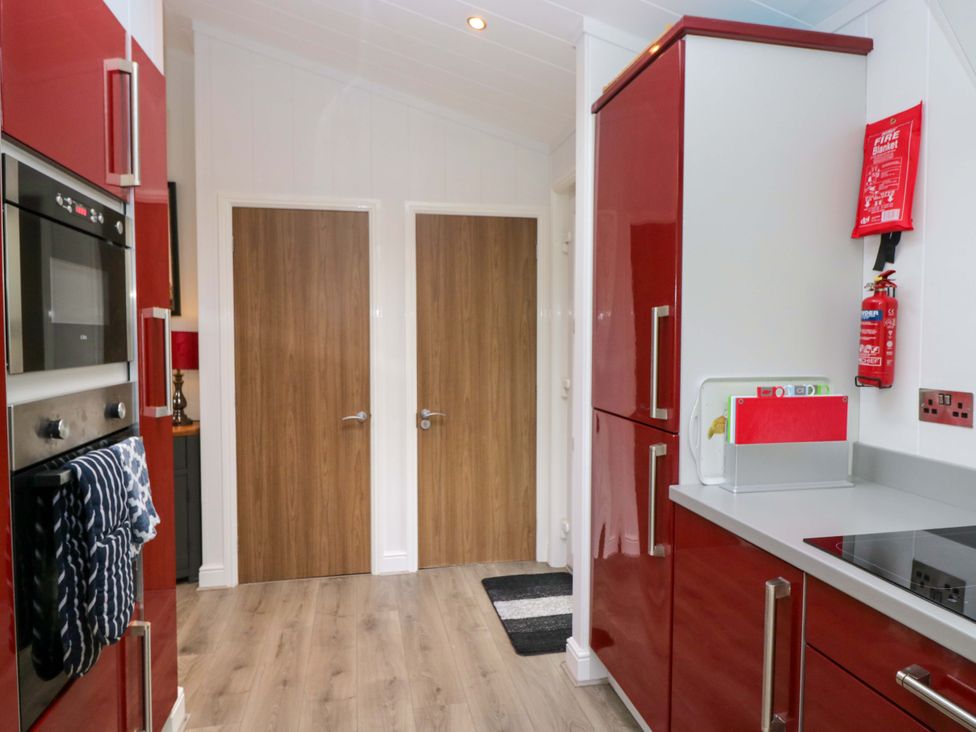 A kitchen with appliances and doors at 5 Waterside Wood Troutbeck Bridge