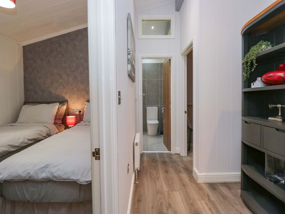 A bedroom with twin beds and a view of the hallway at 5 Waterside Wood Troutbeck Bridge