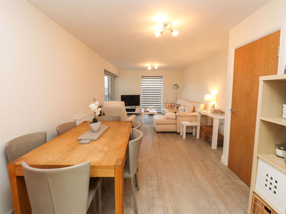 A living room with a dining area and a sofa at Heulfan in Conwy