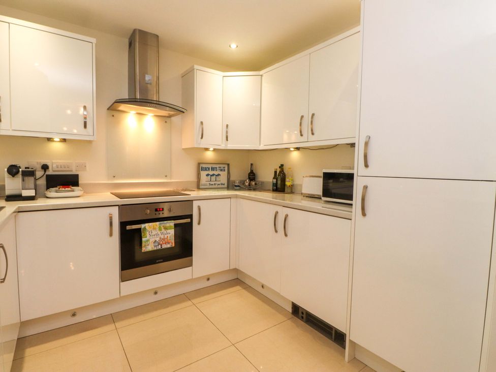 A kitchen with cabinets, oven, and microwave at Heulfan in Conwy