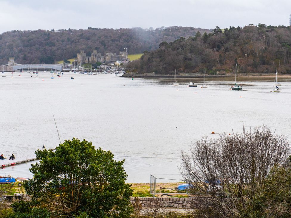 A landscape view of a river with boats and a bridge at Heulfan in Conwy