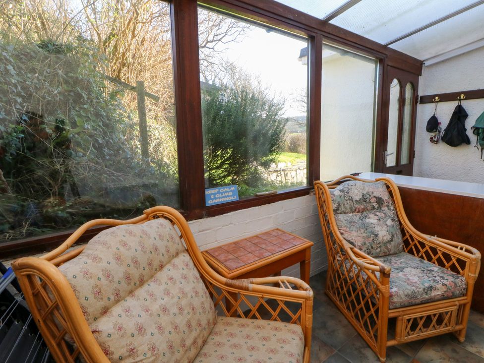 A conservatory with seating and a table at Bryncyn in Newport, Pembrokeshire