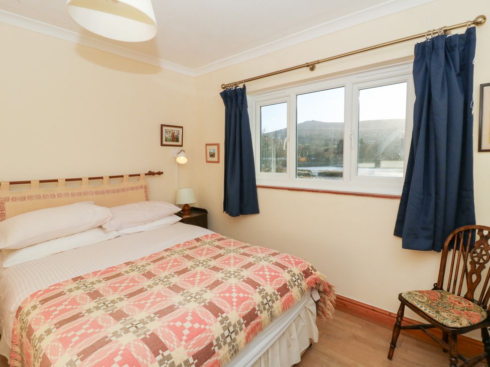 A bedroom with a bed and chair at Bryncyn in Newport, Pembrokeshire