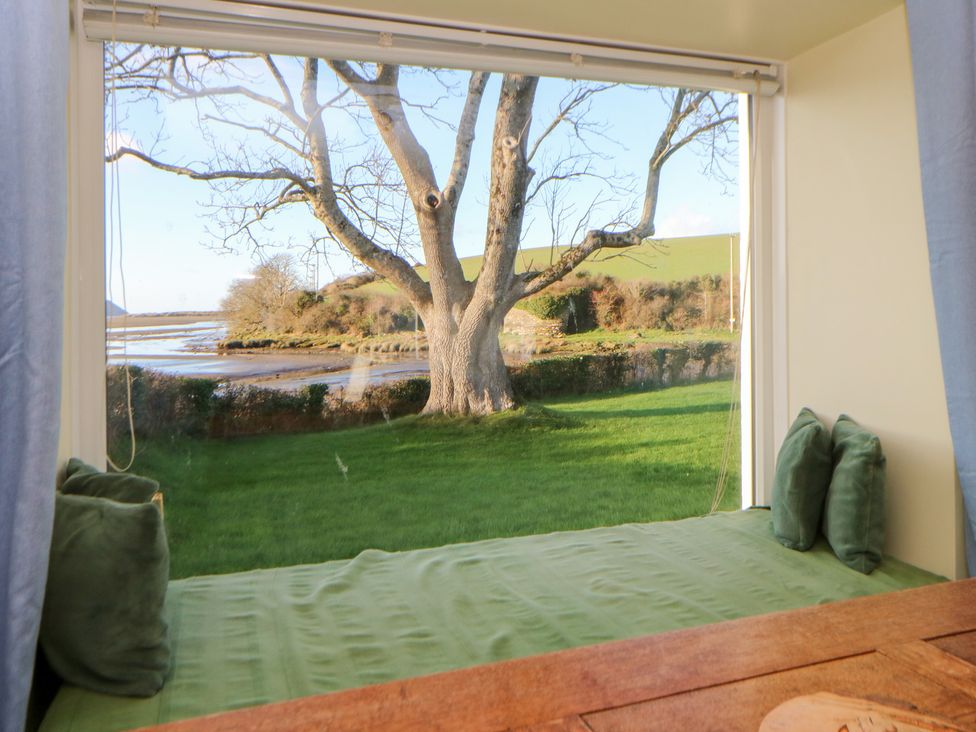 A seating area with cushions and window view at Bryncyn Newport, Pembrokeshire
