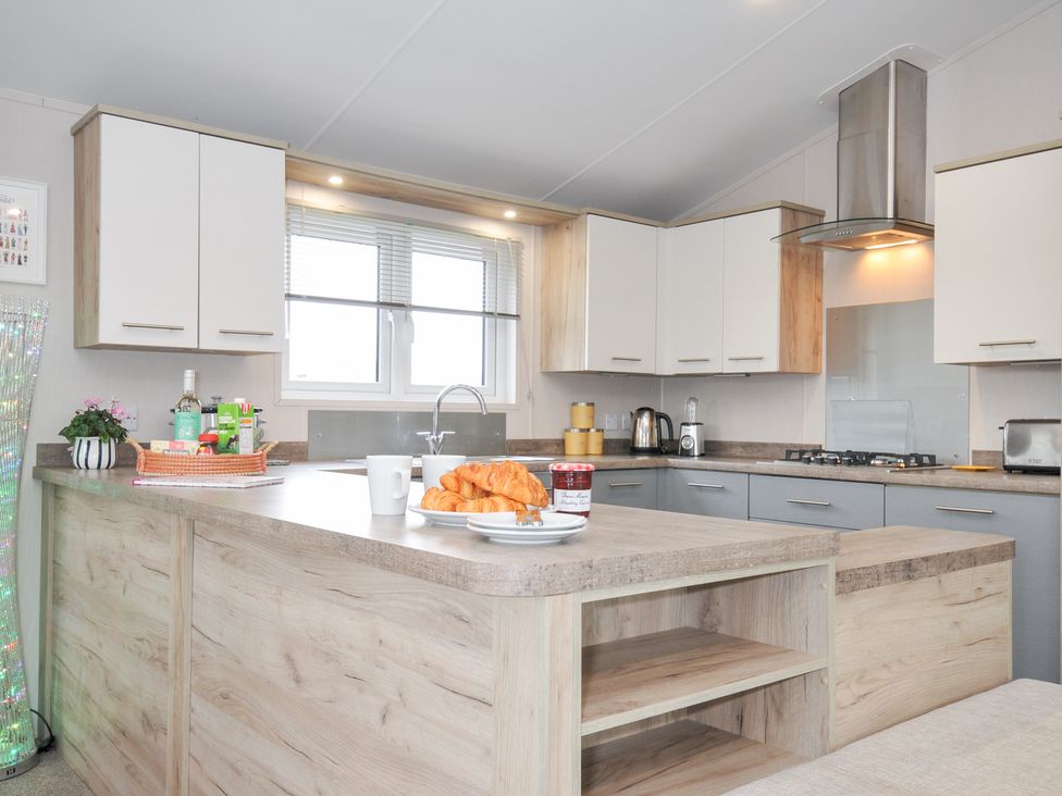 A kitchen with an island and window at 2 Summerleaze in Bude