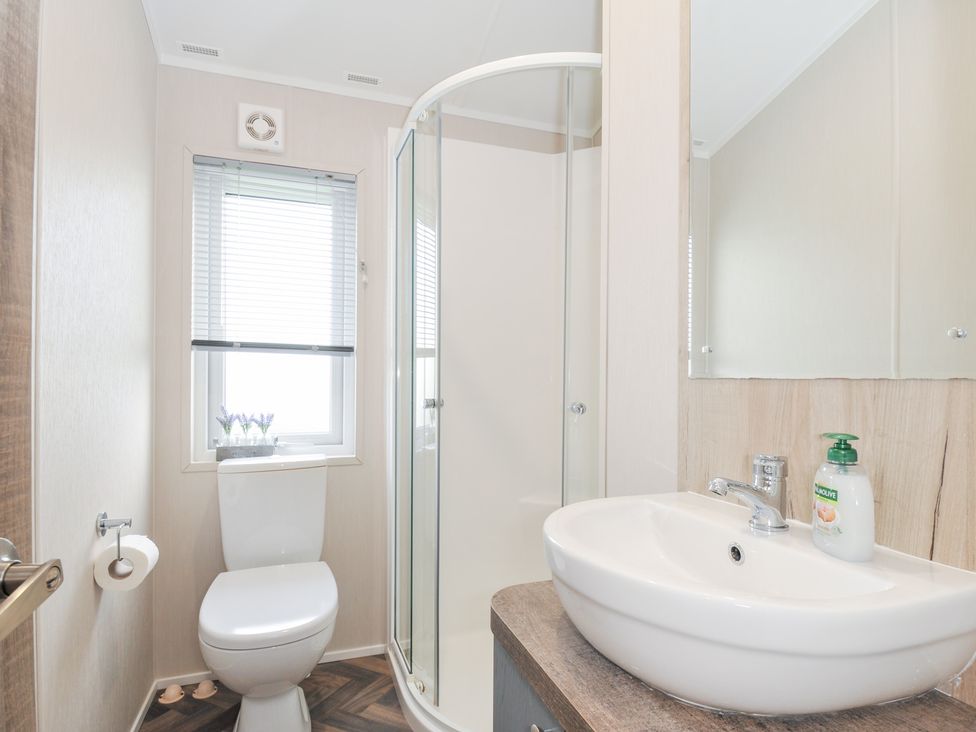A bathroom with a toilet, shower and sink at 2 Summerleaze in Bude