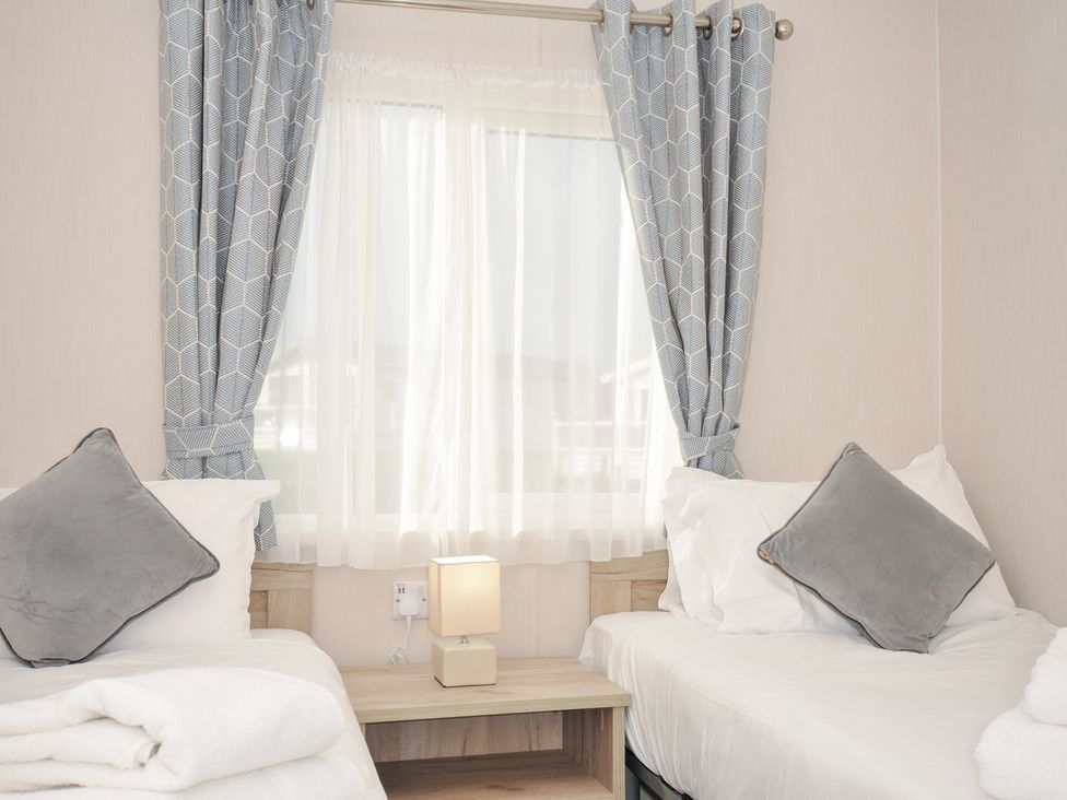 A bedroom with beds and a lamp at 2 Summerleaze Bude