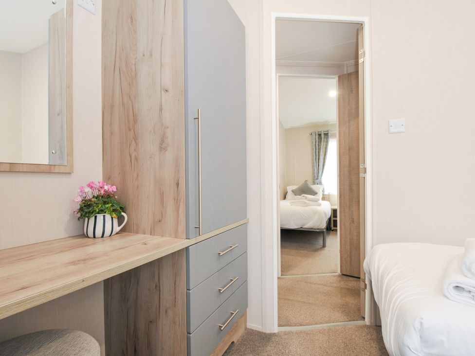 A bedroom with a dresser and a view of another room at 2 Summerleaze in Bude