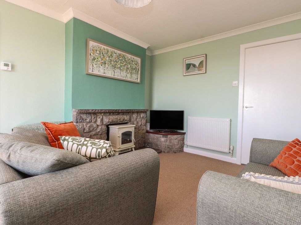A living room with a fireplace and television at Mona View in Amlwch