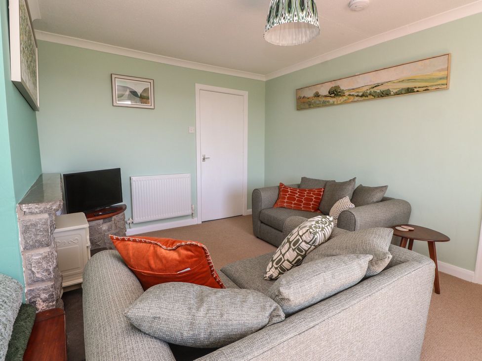 A living room with a television and sofa at Mona View in Amlwch