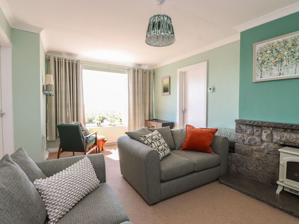 A living room with a sofa and armchair at Mona View in Amlwch