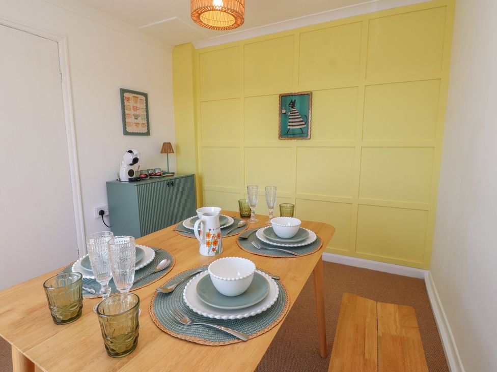 A dining room with a table set for dinner at Mona View in Amlwch