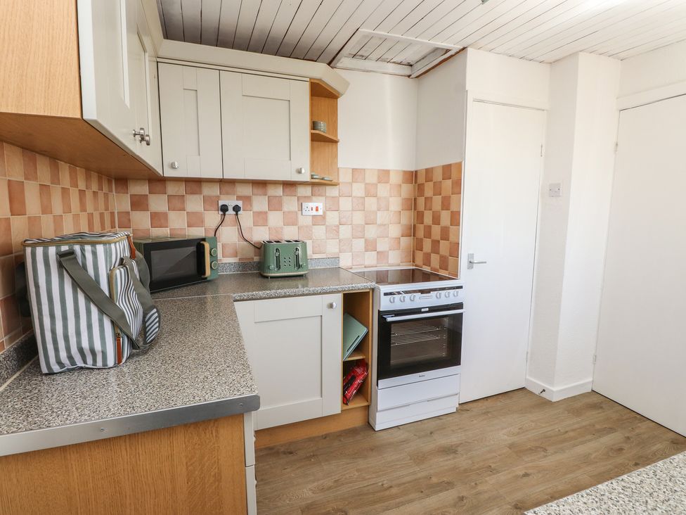 A kitchen with appliances and cabinetry at Mona View in Amlwch