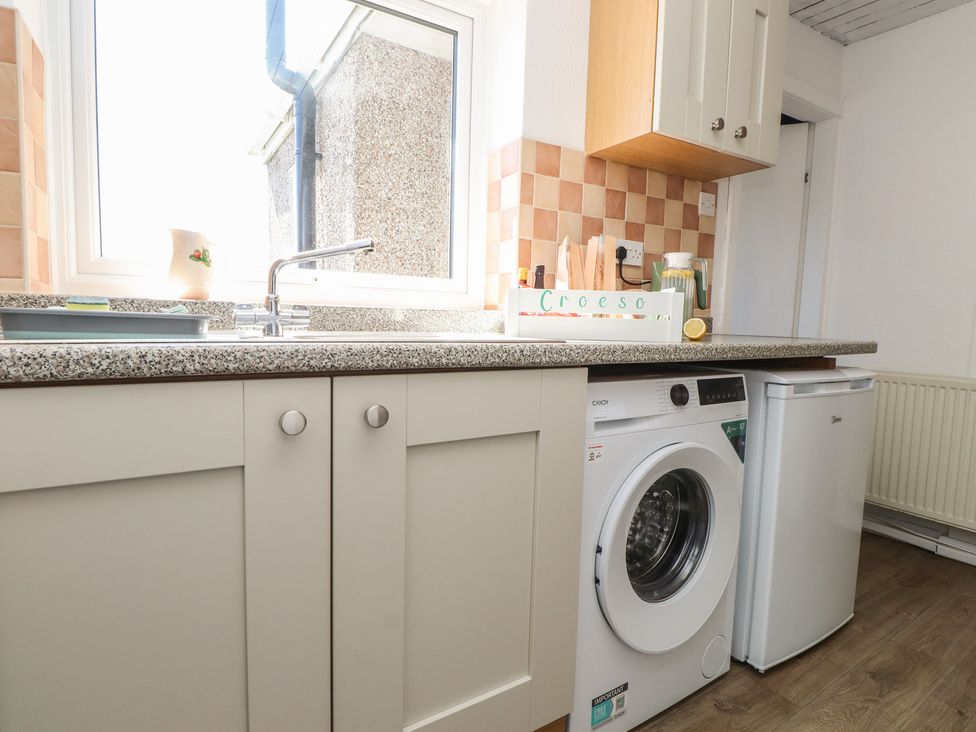 A kitchen with a washing machine and refrigerator at Mona View Amlwch