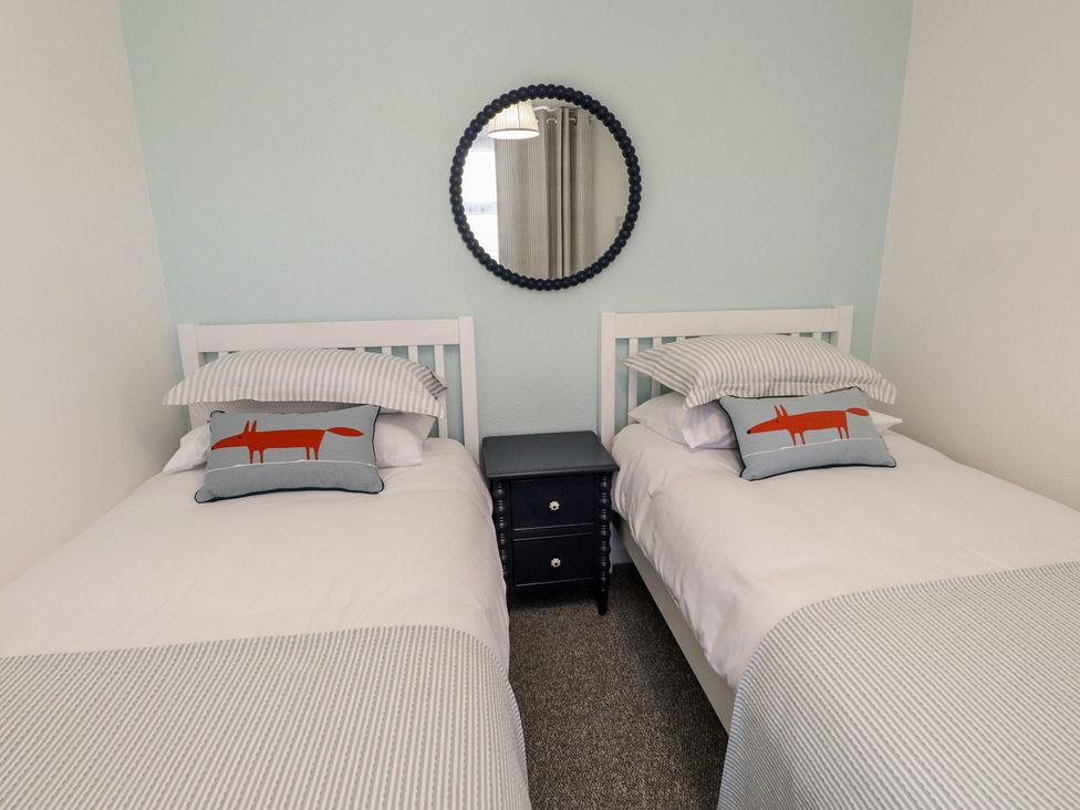 A bedroom with two beds and a nightstand at Mona View in Amlwch