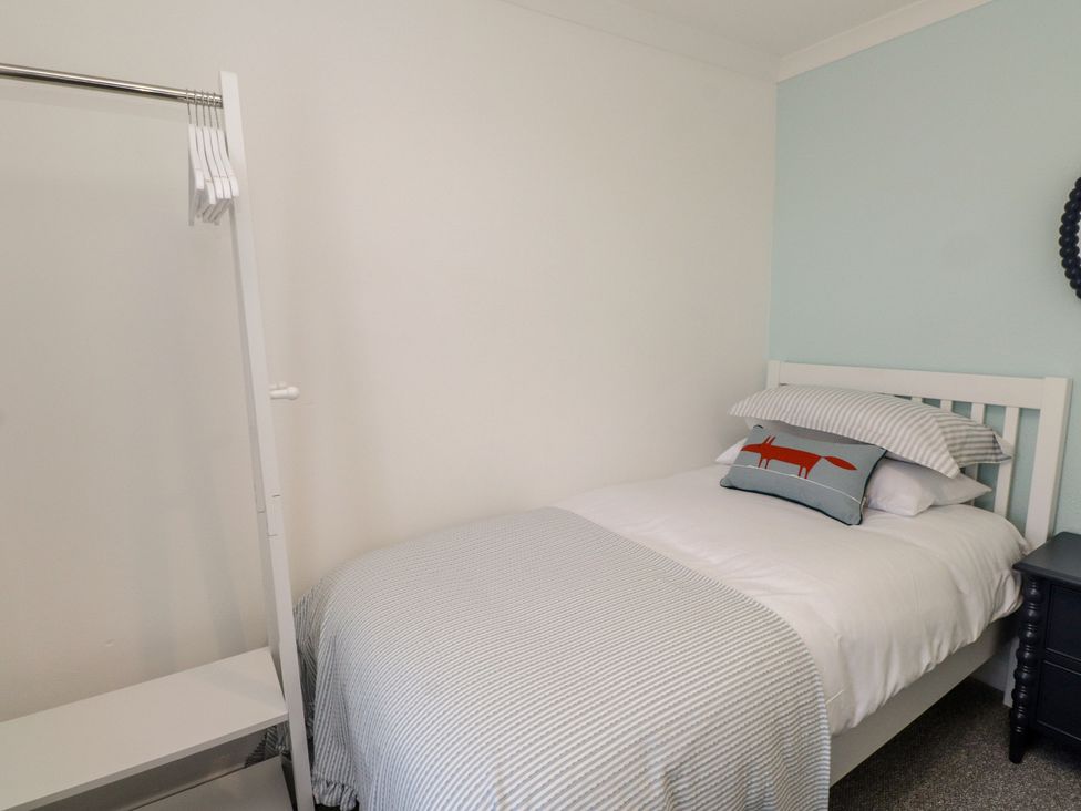 A bedroom with a bed and a hanger rack at Mona View in Amlwch