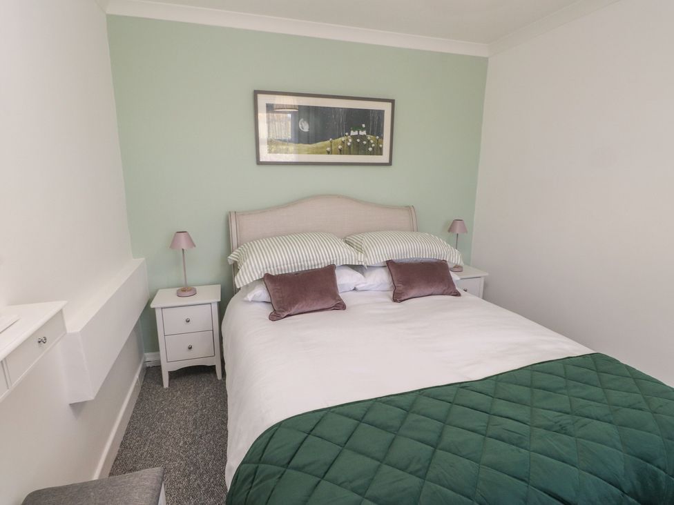 A bedroom with a bed and bedside tables at Mona View in Amlwch