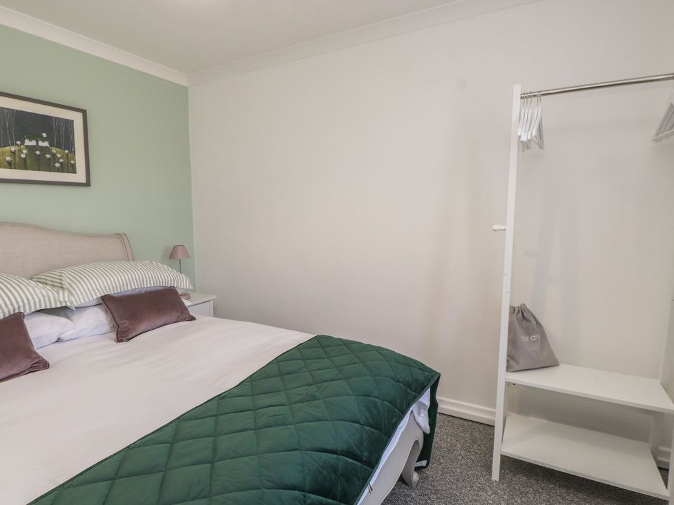 A bedroom with a bed and wardrobe at Mona View in Amlwch