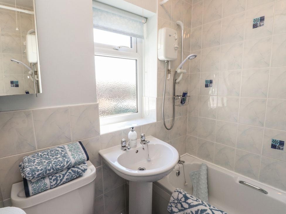 A bathroom with a sink, bathtub, and shower at Mona View, Amlwch