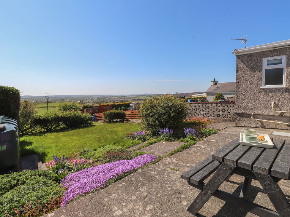 A garden with a table and a view at Mona View in Amlwch