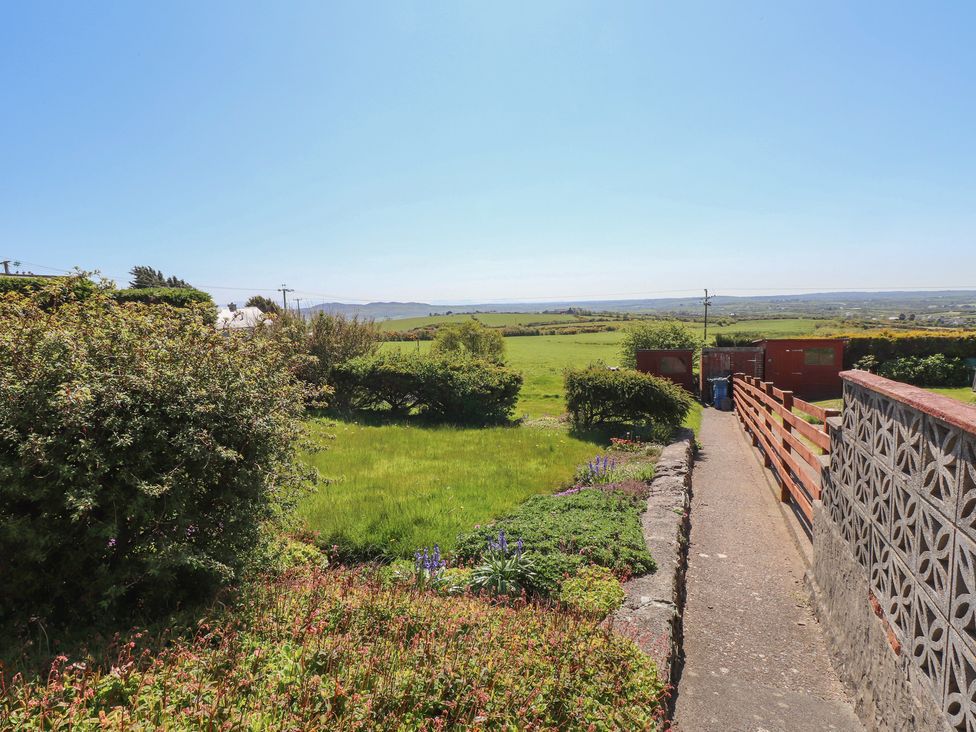 A garden with a pathway and bushes at Mona View in Amlwch