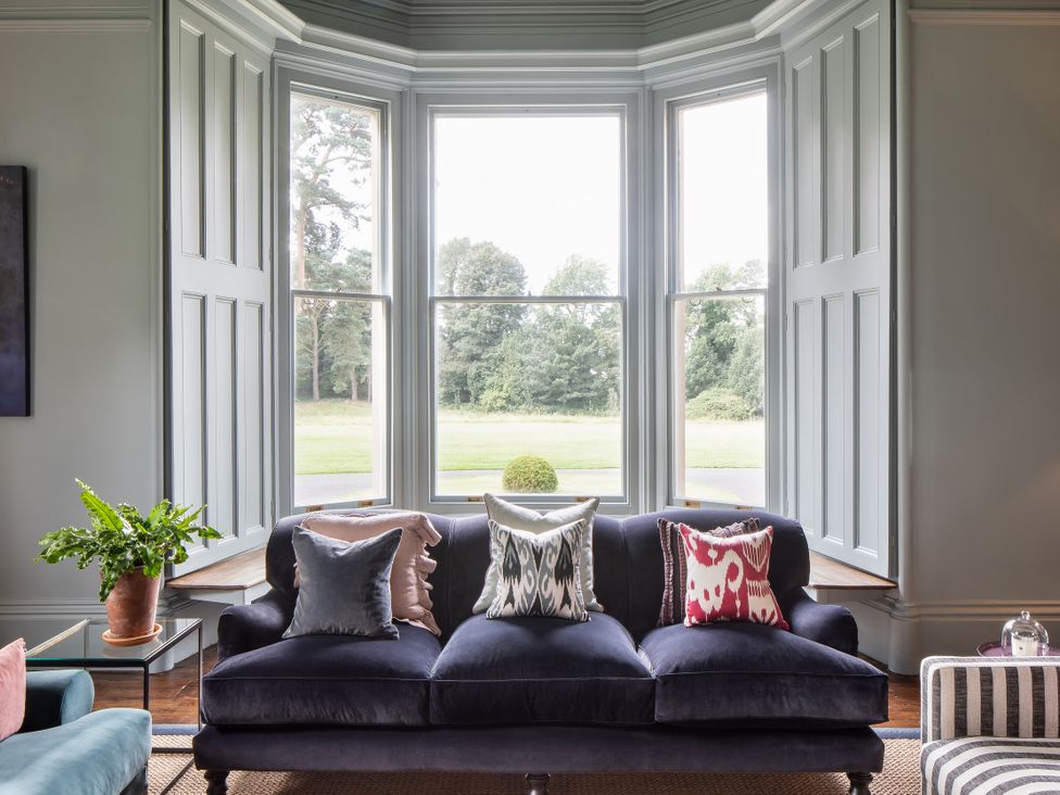 A living room with a sofa and windows at The Country House Cumbria Castle Carrock