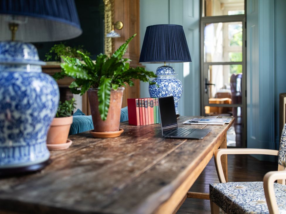 A table with a computer and plants at The Country House Cumbria in Castle Carrock