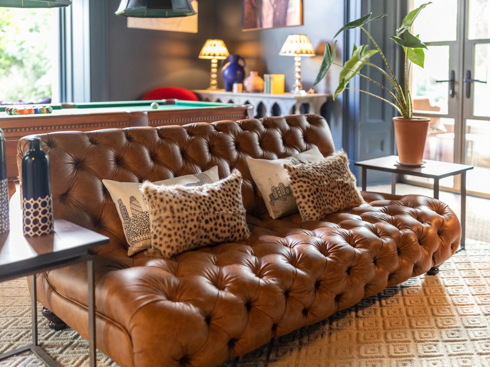 A living room with a sofa and decorative pillows at The Country House Cumbria in Castle Carrock