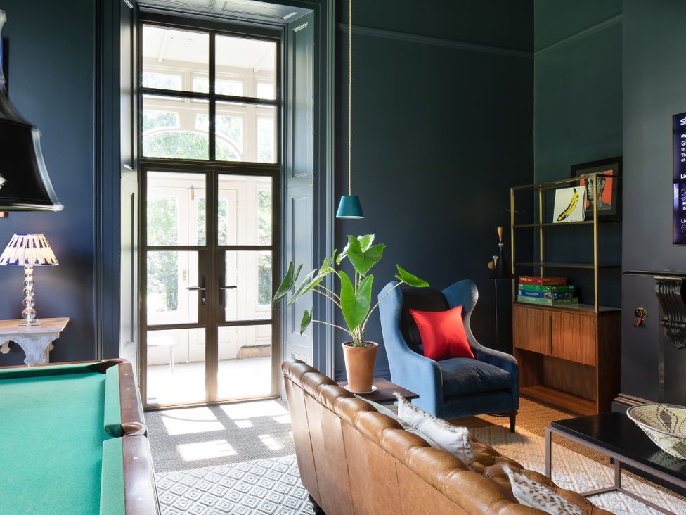 A living room with a pool table and plant at The Country House Cumbria Castle Carrock